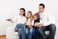 Cheeful young family watching TV at home