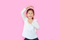 Cheeky little asian kid girl with expression monkey face and hands isolated on pink background. Amusing playful child monkeying Royalty Free Stock Photo