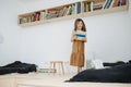 Cheeky little girl walking on an elevated wooden floor with a book in her hands. Royalty Free Stock Photo