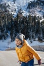 Cheeky perky little girl on a narrow brige holding snowball, wating