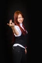 A cheeky, red-haired girl with a grin, dressed as an office worker, on a black background. Royalty Free Stock Photo