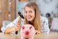 cheeky woman holding hammer over piggybank Royalty Free Stock Photo