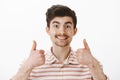 Cheer up man, everything great. Portrait of positive friendly caucasian guy with moustache, raising thumbs up and