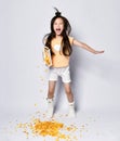 Cheerful and active asian girl kid in home clothes has fun in the morning breakfast and ignores she poures out corn flakes Royalty Free Stock Photo