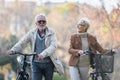 Cheerful active senior couple with bicycle in public park together having fun. Perfect activities for elderly people. Happy mature Royalty Free Stock Photo