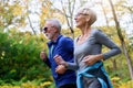 Cheerful active senior couple jogging in the park