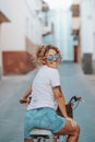 Cheerful active woman riding a bike in the street town and looking back smiling. Green transport and active healthy lifestyle Royalty Free Stock Photo