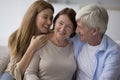 Cheerful adult daughter and senior husband hugging mature mom Royalty Free Stock Photo