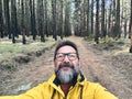 Cheerful adult happy man taking selfie picture in the woods enjoying outdoors leisure activity in national forestal park alone. Royalty Free Stock Photo