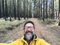 Cheerful adult happy man taking selfie picture in the woods enjoying outdoors leisure activity in national forestal park alone. Royalty Free Stock Photo