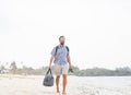 Cheerful adult man with bag having fun on tropical beach