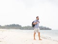 Cheerful adult man with bag having fun on tropical beach