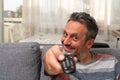 Cheerful adult man sick at home zapping tv from sofa