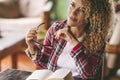 Cheerful adult pretty woman enjoy reading book at home sitting on the table. Attractive female people in wooden living room with Royalty Free Stock Photo