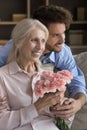 Cheerful adult son and happy senior mom celebrating mothers day Royalty Free Stock Photo