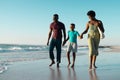 Cheerful african american boy holding father and mother\'s hands and walking at shore against sky Royalty Free Stock Photo