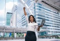 African American business woman with arms raised in success and hold laptop Royalty Free Stock Photo