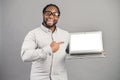 Smiling African-American man with laptop isolated on grey Royalty Free Stock Photo