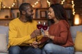 Cheerful african american couple relaxing at home, drinking wine Royalty Free Stock Photo