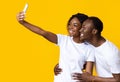 Cheerful african american couple taking selfie on smartphone, side view Royalty Free Stock Photo