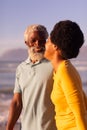 Cheerful african american couple talking while standing at beach and clear blue sky at sunset Royalty Free Stock Photo