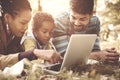 African American family lying down in park and using la Royalty Free Stock Photo