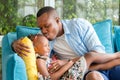 Cheerful african american father and daughter playing in living room, Young dad kissing cheerful baby, Happiness family concepts Royalty Free Stock Photo