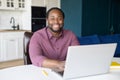 Cheerful African-American freelancer is using laptop for work on the distance Royalty Free Stock Photo