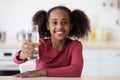 Cheerful african american girl teenager holding glass of fresh water Royalty Free Stock Photo