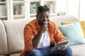 Cheerful african american guy using digital tablet at home Royalty Free Stock Photo