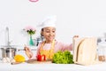 cheerful african american kid in apron and chef hat cooking