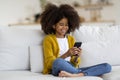 Cheerful african american little girl using smartphone at home Royalty Free Stock Photo