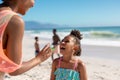 Cheerful african american mother and daughter enjoying sunny day at beach with family, copy space Royalty Free Stock Photo