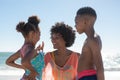 Cheerful african american mother with son and daughter enjoying summer holiday at beach Royalty Free Stock Photo