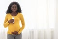 Cheerful african american pregnant woman holding glass of milk Royalty Free Stock Photo