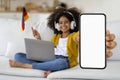 Cheerful african american school girl with wireless headset using laptop Royalty Free Stock Photo