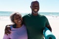 Cheerful african american senior couple spending vacation at beach against sea and clear sky Royalty Free Stock Photo