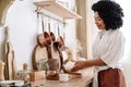 african american woman pouring tea in cup at kitchen Royalty Free Stock Photo