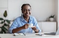 Cheerful African American Woman Enjoying Coffee At Workplace In White Office Royalty Free Stock Photo