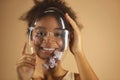 Cheerful african american woman in full face protective transparent shield decorated with flowers