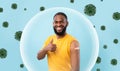 Cheerful african american young guy show shoulder with plaster after vaccination and thumb up