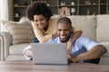 African couple sit in living room have fun use laptop Royalty Free Stock Photo