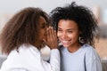 Cheerful african daughter whisper to mothers ear a secret