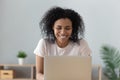Cheerful african girl laughing watching funny online show on laptop Royalty Free Stock Photo