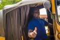 cheerful african man driving a tuk tuk taxi smiling giving a thumbs up to someone Royalty Free Stock Photo