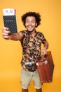 Cheerful african man holding passport and suitcase Royalty Free Stock Photo