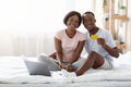 Cheerful african man and woman with laptop showing credit card