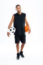 Cheerful african sports man holding basketball and soccer ball Royalty Free Stock Photo