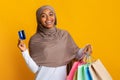 Cheerful Afro Islamic Woman In Headscarf With Credit Card And Shopping Bags Royalty Free Stock Photo