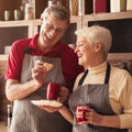 Cheerful Aged Couple Eating Homemade Cookies And Drinking Tea In Kitchen